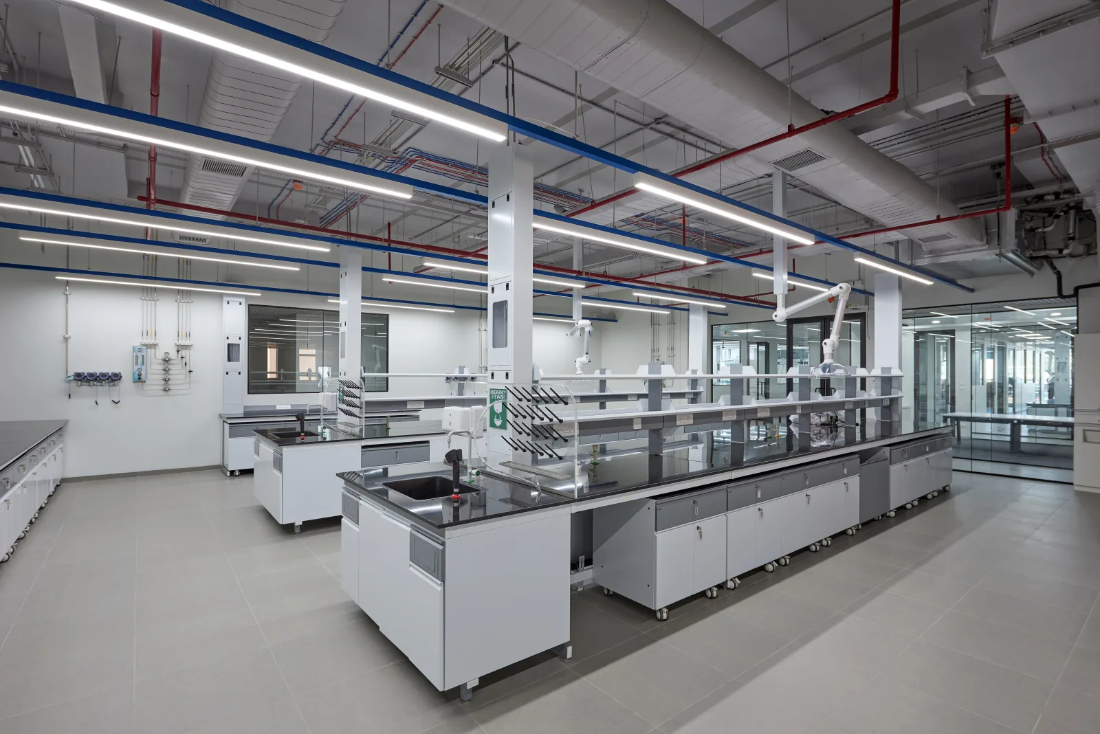 Open-plan analytical laboratory with island benches and serviced reagent racks