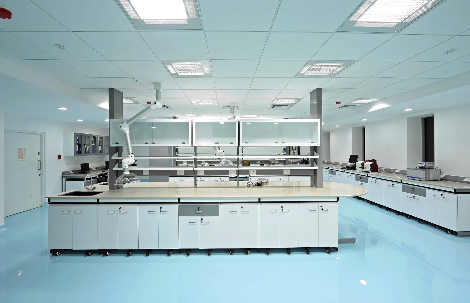 Quality control laboratory with blue epoxy floor, island benches and reagent shelving