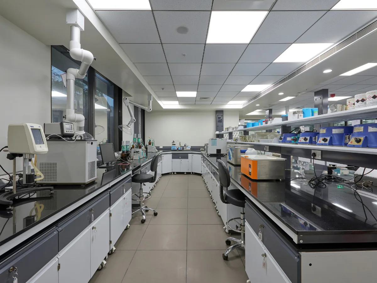 Wide lab with dual bench runs, spot extractors and reagent shelves