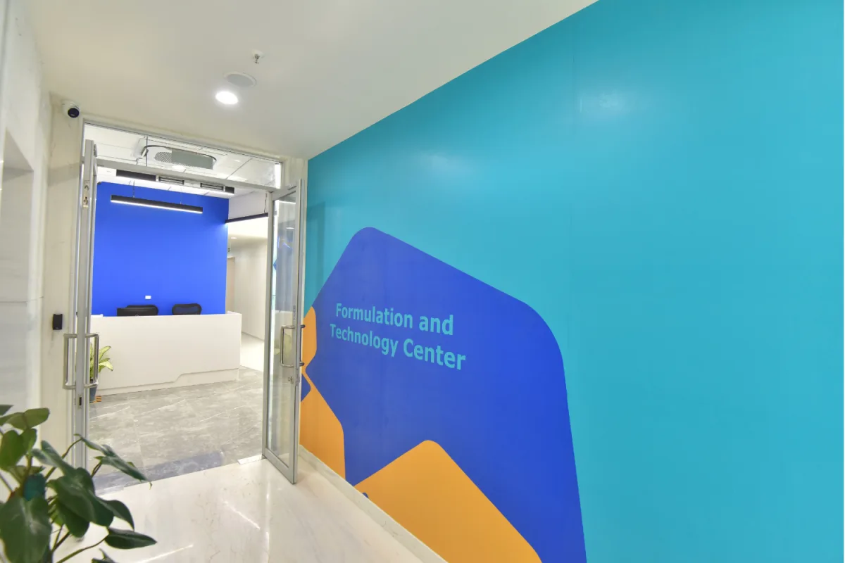 Entrance corridor with teal Formulation and Technology Center graphic wall