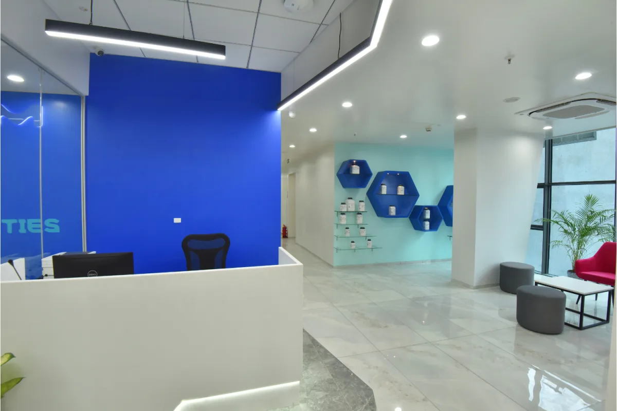 Reception with blue wall, hexagonal product display and linear ceiling lights