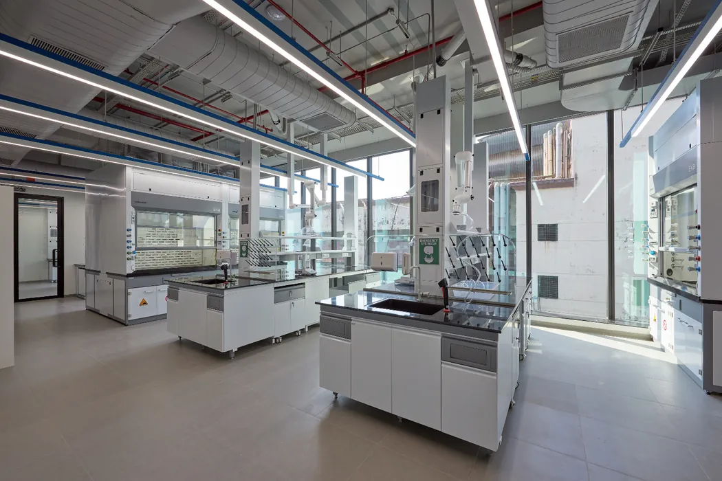 Daylit laboratory with fume hoods, island benches and eyewash stations