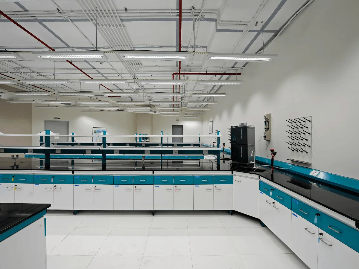 Teal island benches with analytical instrument and pegboard