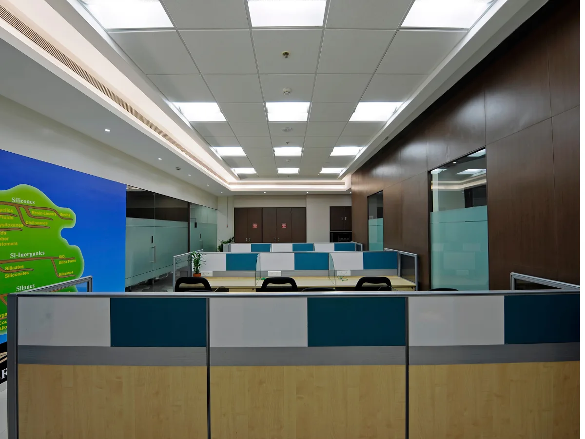 Workstation cubicles with product display wall and dark wood paneling