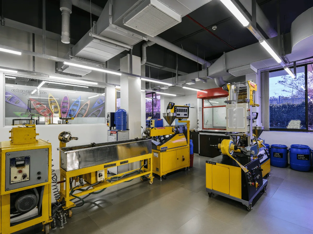 Plastic lab with yellow extruders, water bath and product display mural