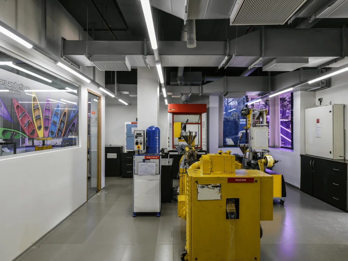 Plastic lab with yellow equipment and 'colors and effects' mural