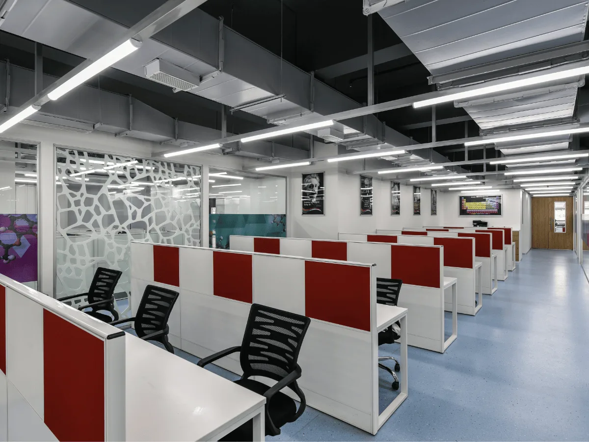 Open-plan workstations with red dividers and organic-pattern glass partition