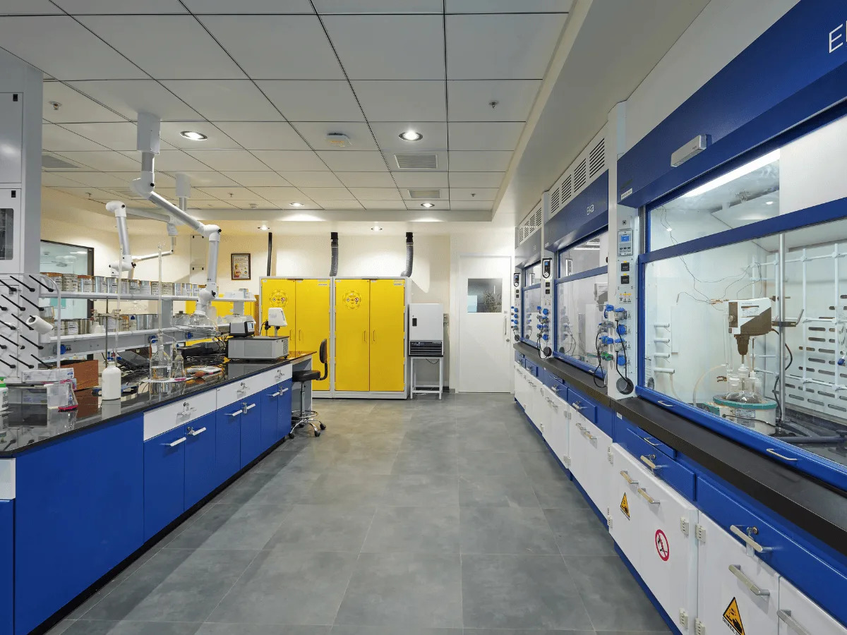 Lab with fume hoods, yellow safety cabinets and spot extractors