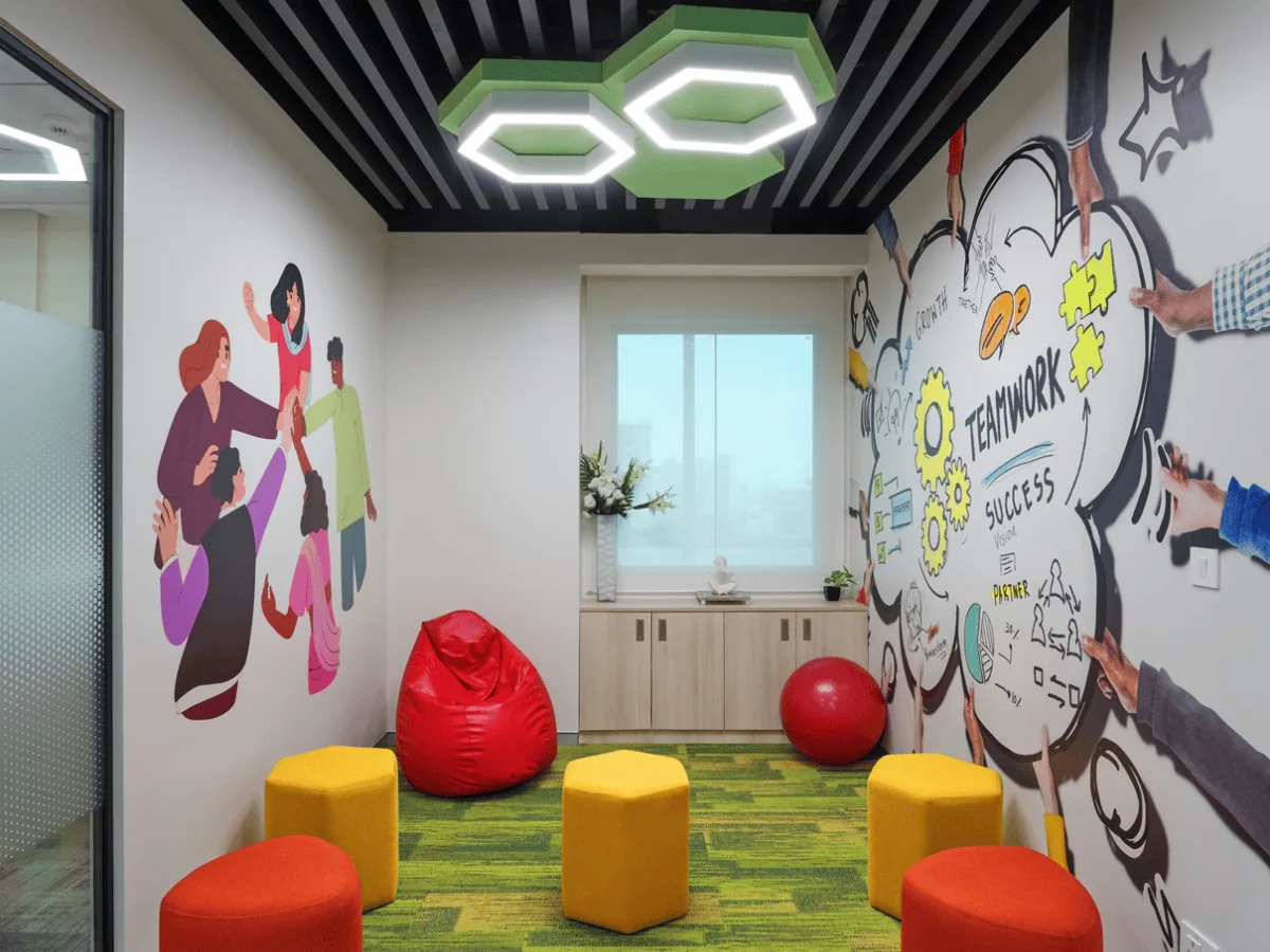 Breakout zone with bean bags, hexagonal poufs and teamwork mural