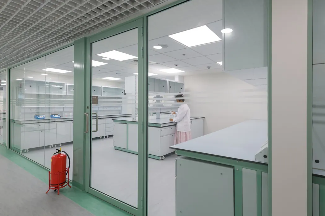 Analytical laboratory viewed through mint-green glass partition