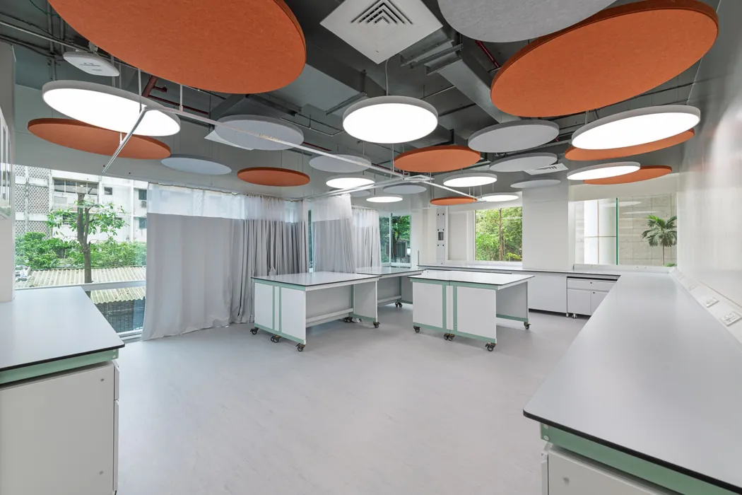 Application and sensory space with orange acoustic ceiling discs and mobile island benches