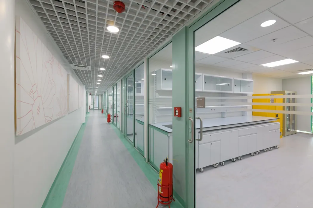 Laboratory corridor with mint-green glass partitions and lotus-motif wall mural