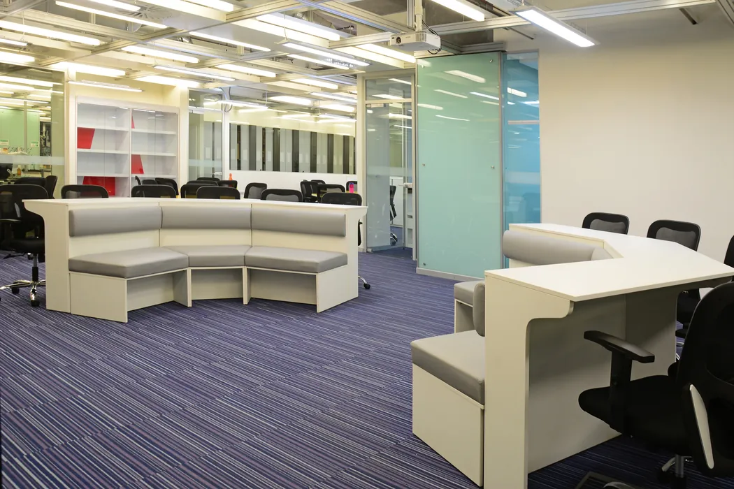 Office breakout area with curved banquette seating and purple carpet