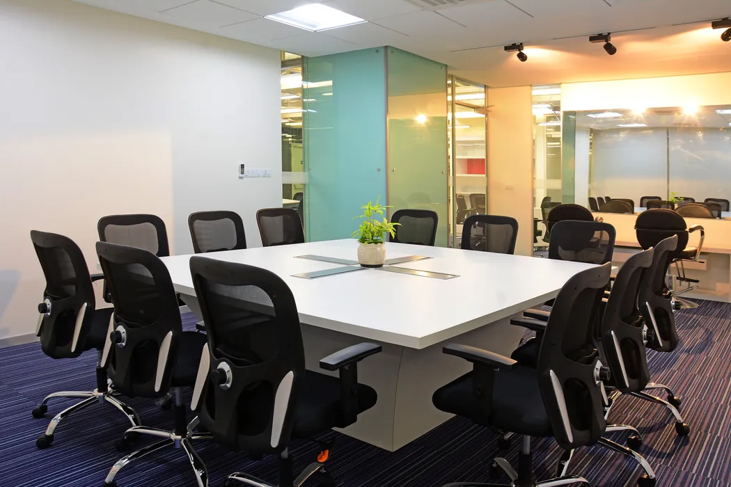 Conference room with white table, black chairs and purple carpet