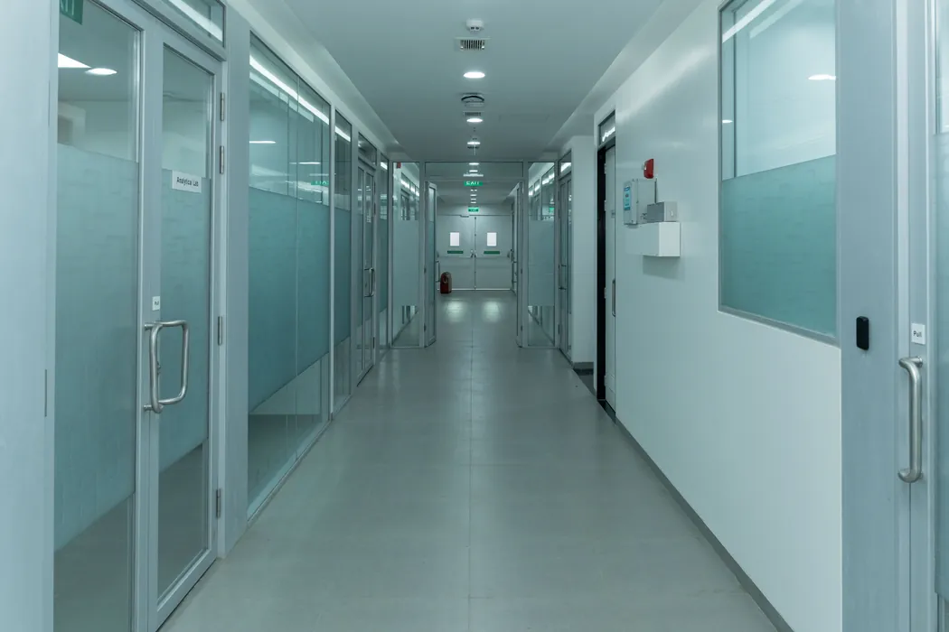 Glass-partitioned laboratory corridor with analytical lab signage