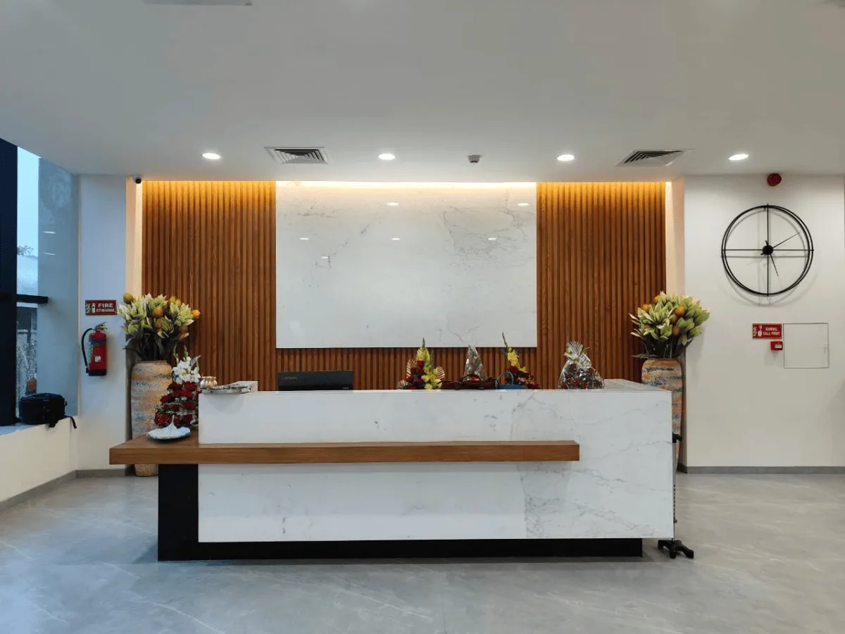 Marble and wood-panelled reception desk with ambient lighting