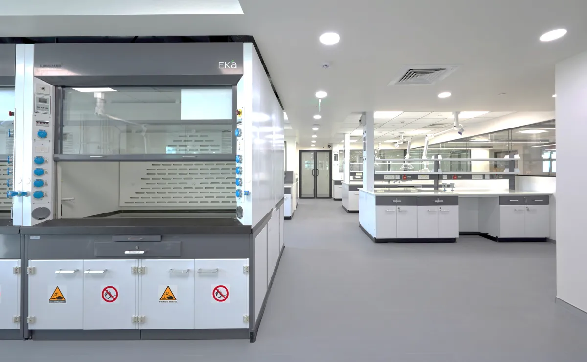 Fume hood with chemical storage cabinets and island benches