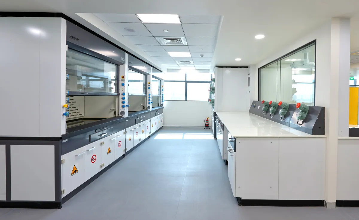 Fume hoods with safety hazard stickers and eyewash stations