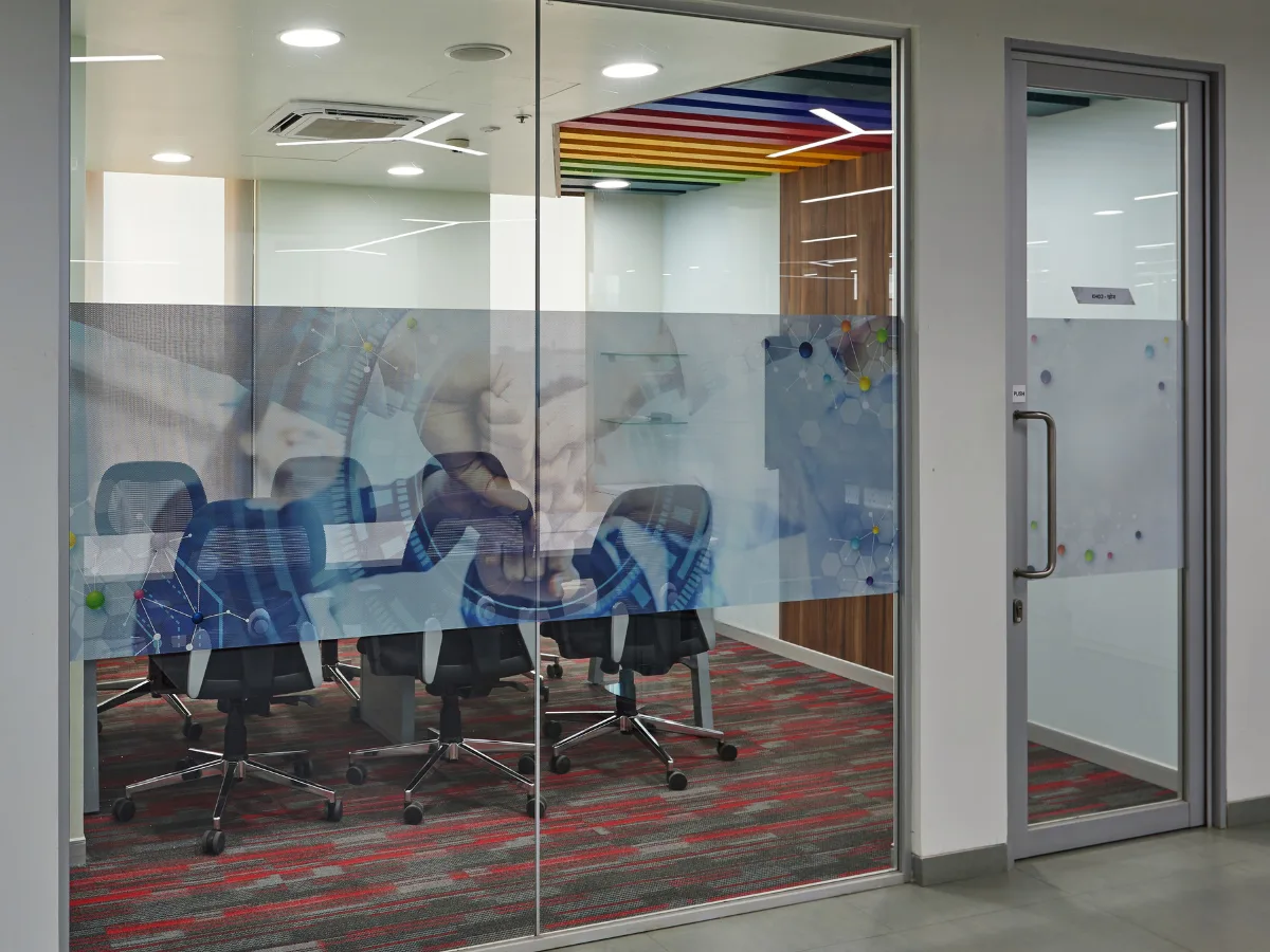 Glass-walled meeting room with molecular art graphics and rainbow ceiling