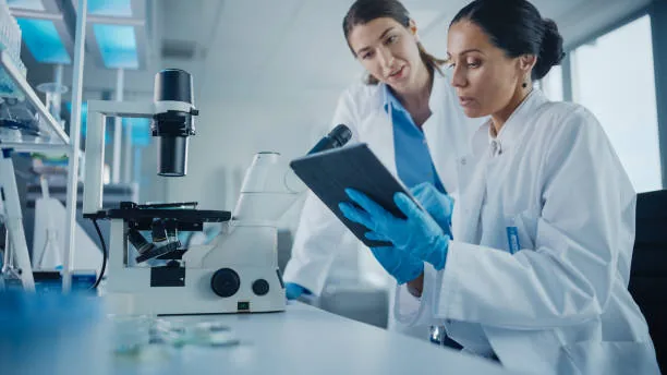 Researcher using a tablet to monitor laboratory equipment